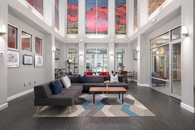 Modern lounge with sectional couch coffee table and art at Lux 13 in Gainesville Student Accommodation