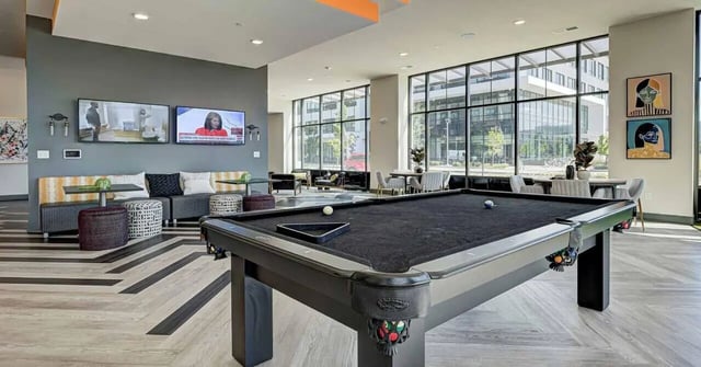 Pool table seating area lounge and large windows. at Continuum Apartments in Gainesville Student Accommodation