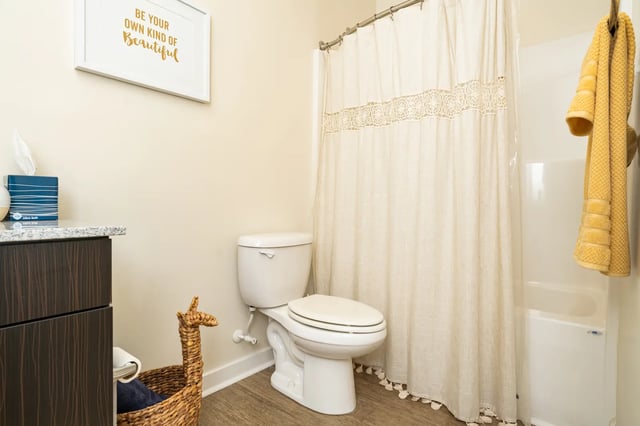Toilet shower curtain towels basket bathroom at The Retreat at Tampa in Tampa Student Accommodation