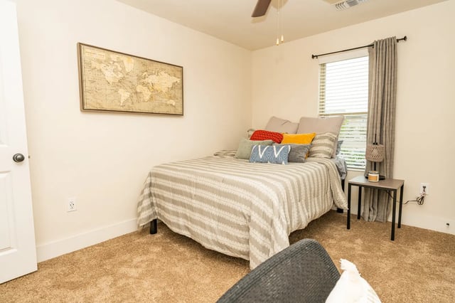 Bed with pillows world map and window bedroom at The Retreat at Tampa in Tampa Student Accommodation