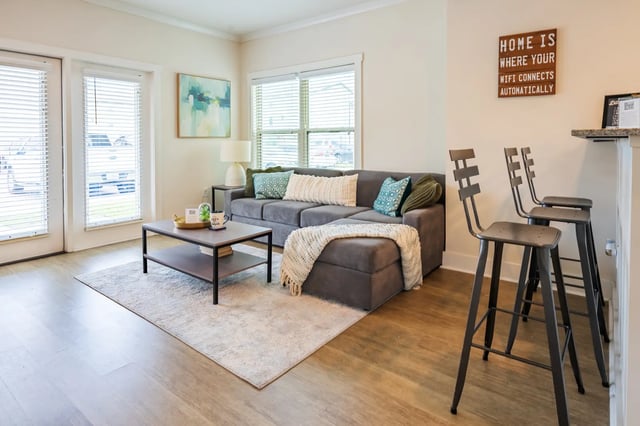 Sofa coffee table rug and stools living room at The Retreat at Tampa in Tampa Student Accommodation