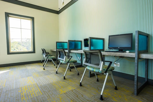 Computers and chairs line a desk study area at The Retreat at Tampa in Tampa Student Accommodation