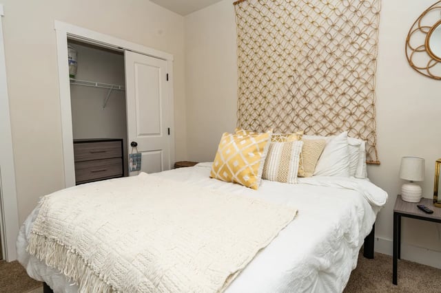 Bed with pillows dresser closet and wall hanging bedroom at The Retreat at Tampa in Tampa Student Accommodation