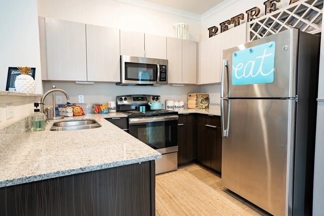 Stainless steel refrigerator with "eat" sign kitchen at The Retreat at Tampa in Tampa Student Accommodation