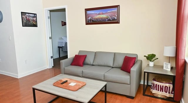 Gray sofa coffee table and framed pictures living room at Burt Reynolds Hall in Tallahassee Student Accommodation