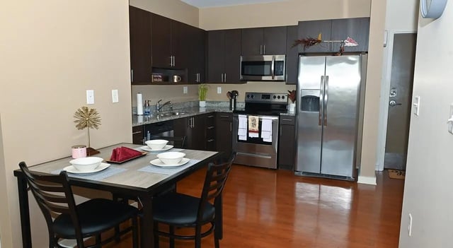 Dining table and kitchen with stainless steel appliances kitchen at Burt Reynolds Hall in Tallahassee Student Accommodation