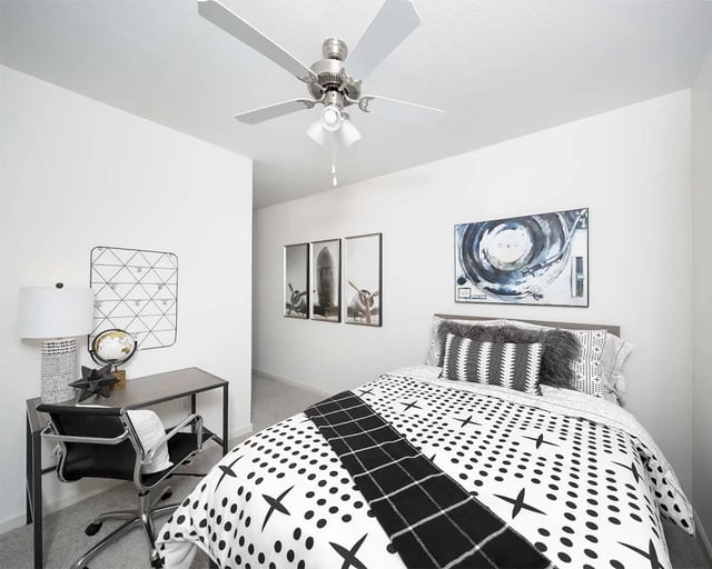 Bed desk lamp globe and ceiling fan bedroom at Urban Enclave in Tallahassee Student Accommodation
