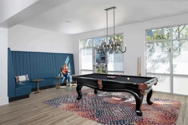 Pool table with balls blue banquette rug living room at Urban Enclave in Tallahassee Student Accommodation