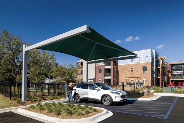Car charging under canopy exterior of apartment buildings at Urban Enclave in Tallahassee Student Accommodation
