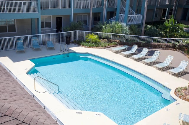 Pool with lounge chairs and building exterior view at Museum Walk in Gainesville Student Accommodation