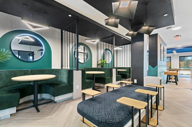Green booths with tables and modern sofa seating communal area at Monarch in Gainesville Student Accommodation