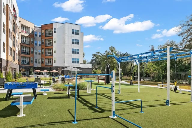 Apartment buildings with outdoor gym equipment and foosball exterior at Monarch in Gainesville Student Accommodation