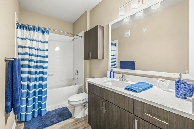 White toilet blue striped curtain vanity mirror bathroom at IQ Apartments in Tampa Student Accommodation