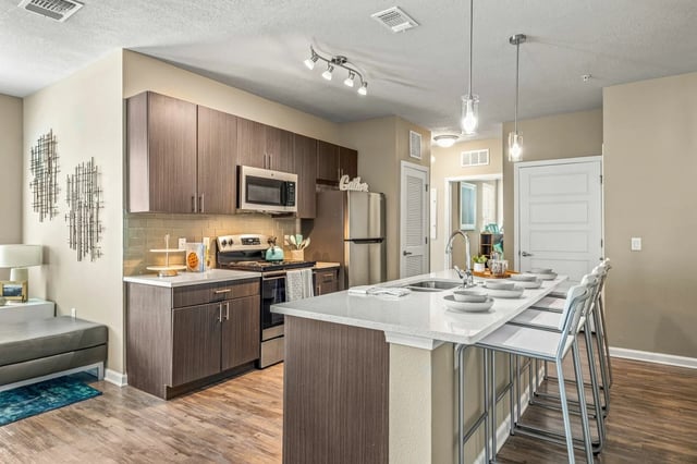 Modern kitchen with island, stools, and appliances Kitchen at IQ Apartments in Tampa Student Accommodation