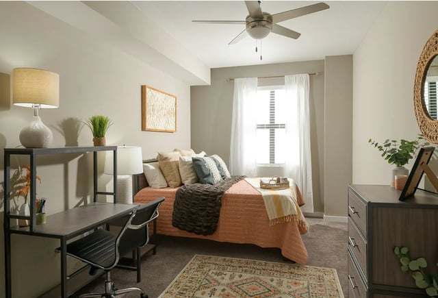 Bed desk chair pillows rug bedroom at The Metropolitan Tampa in Tampa Student Accommodation