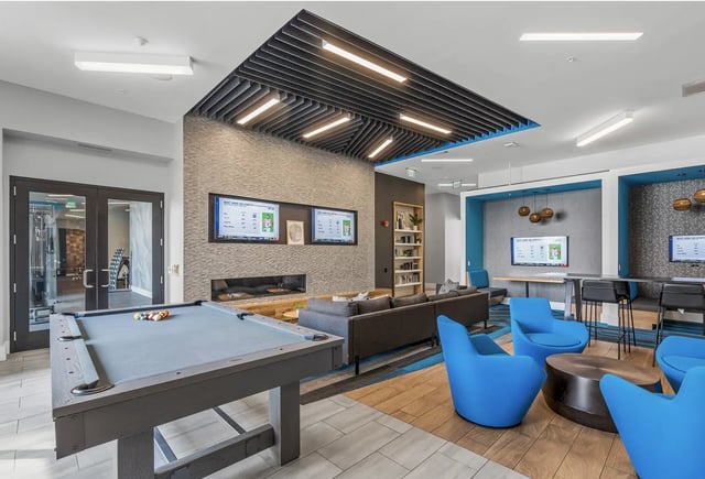 Pool table couches TVs and blue chairs communal area at The Metropolitan Tampa in Tampa Student Accommodation