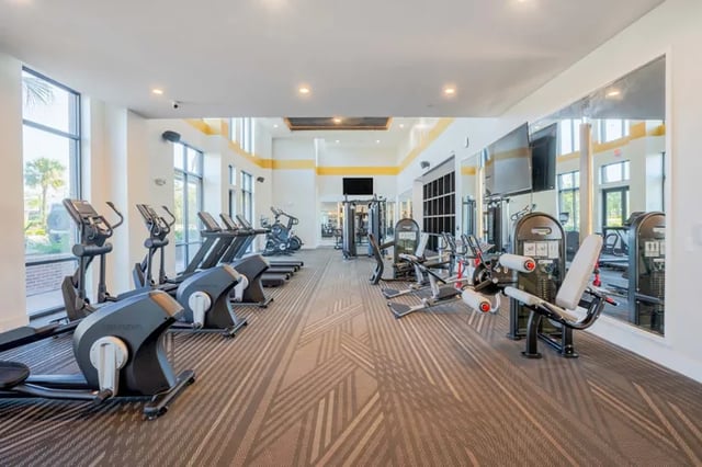 Gym with treadmills ellipticals weight machines fitness room at The Accolade Collegiate Village East in Orlando Student Accommodation