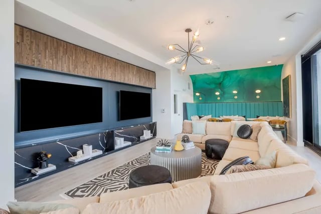 Sectional couch with TVs and green accent wall Living Room at The Accolade Collegiate Village East in Orlando Student Accommodation