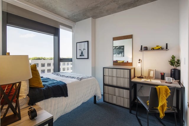 Bed desk dresser mirror lamp and picture bedroom at The One at University City in Miami Student Accommodation