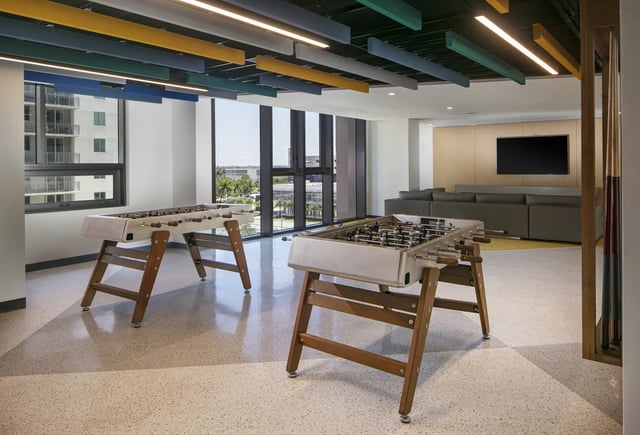 Two foosball tables with lounge seating playing area at The One at University City in Miami Student Accommodation