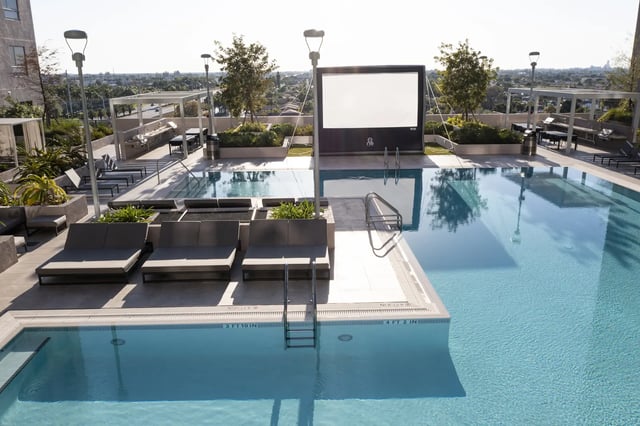 Pool loungers outdoor movie screen swimming pool exterior at The One at University City in Miami Student Accommodation