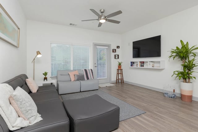 Gray sectional sofa with ottoman and living room living room at College Park at Midtown in Gainesville Student Accommodation