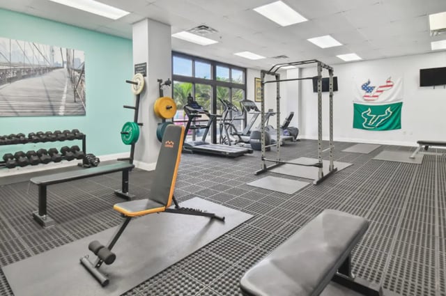 Gym equipment with weights and benches Gym at Malibu Apartments in Tampa Student Accommodation