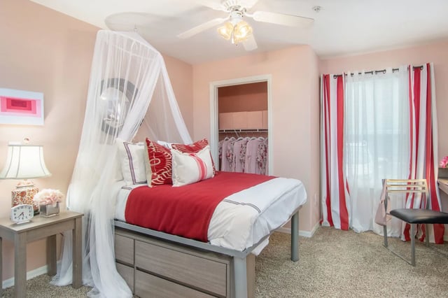 Bed with canopy closet visible red curtains bedroom at The Social Tampa in Lutz Student Accommodation