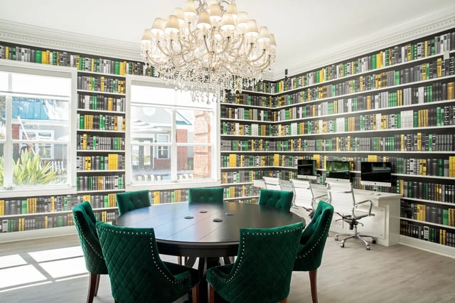 Round table with green chairs study desks computers living room at The Social Tampa in Lutz Student Accommodation