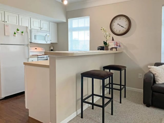Refrigerator stove counter two bar stools kitchen at The Flats at 4200 in Tampa Student Accommodation