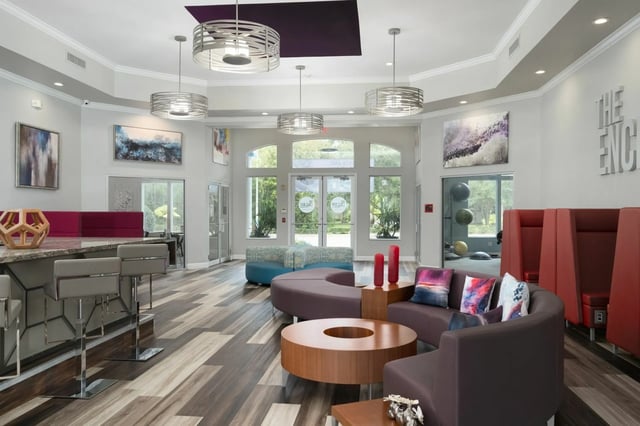 Bar stools curving couch and coffee table lounge at The Enclave in Gainesville Student Accommodation