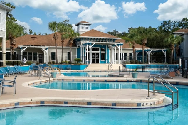 Resort style pools with lounge chairs exterior at The Enclave in Gainesville Student Accommodation