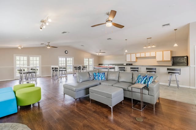 Gray sectional sofa blue green ottomans living room at Greenwich Green Aspen Ridge in Gainesville Student Accommodation