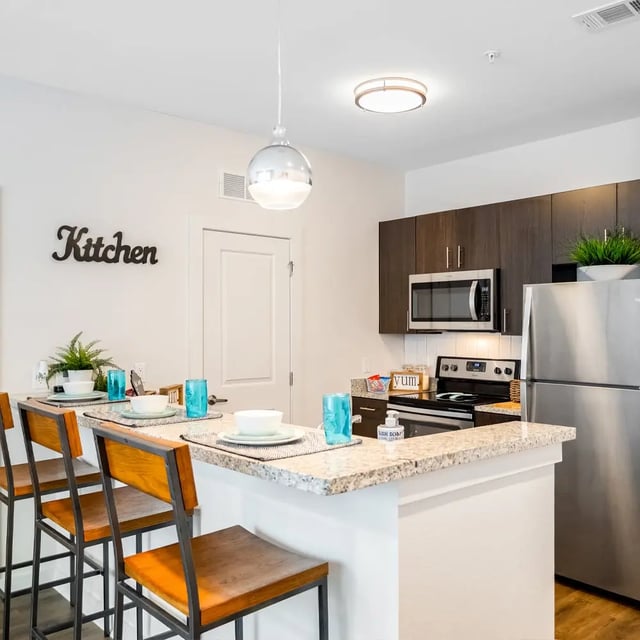 Bar stools and kitchen counter with appliances kitchen at Halo 46 in Tampa Student Accommodation