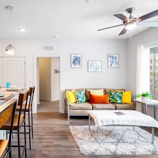 Sofa with colorful pillows and coffee table Living room at Halo 46 in Tampa Student Accommodation