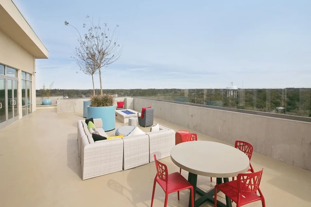 Rooftop patio with sectional sofa fire pit outdoor dining area exterior at The Standard at Gainesville in Gainesville Student Accommodation