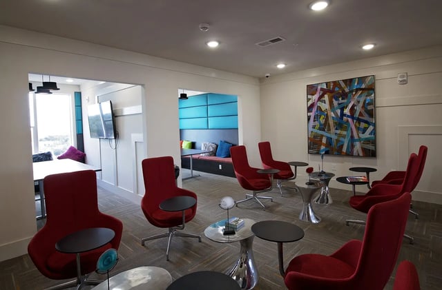 Red chairs and tables in lounge living room at The Standard at Gainesville in Gainesville Student Accommodation