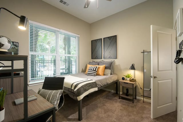 Bed desk chair and pillows bedroom at The Metropolitan Gainesville in Gainesville Student Accommodation