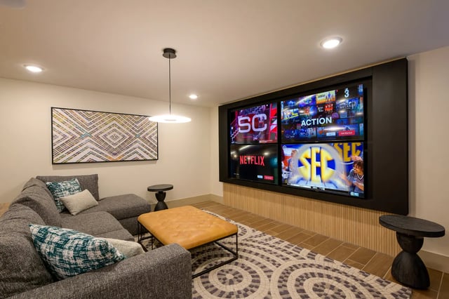 Lounge area with sectional sofa and six TVs living room at The Metropolitan Gainesville in Gainesville Student Accommodation