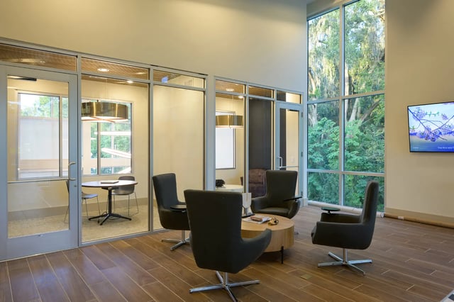 Chairs around coffee table large window living area at The Metropolitan Gainesville in Gainesville Student Accommodation