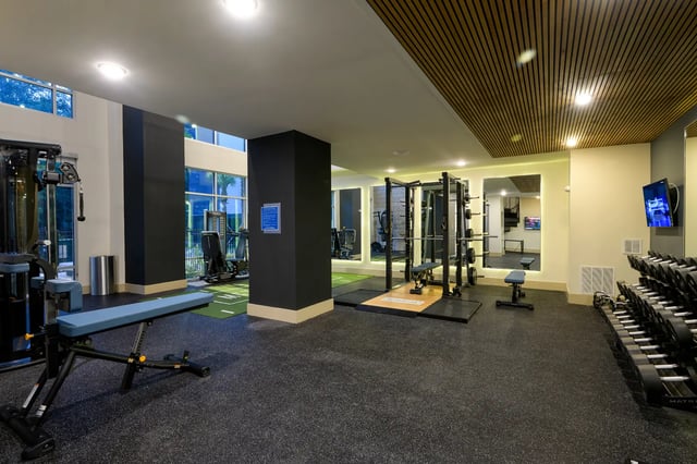 Weight machines bench and dumbbells gym area at The Metropolitan Gainesville in Gainesville Student Accommodation