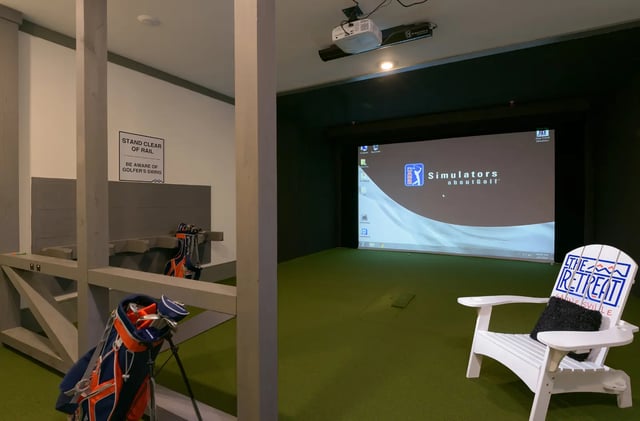 Golf simulator setup with chairs and clubs entertainment area at The Retreat at Gainesville in Gainesville Student Accommodation