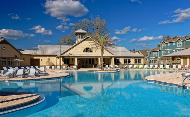 Large swimming pool with lounge chairs and building exterior at The Retreat at Gainesville in Gainesville Student Accommodation