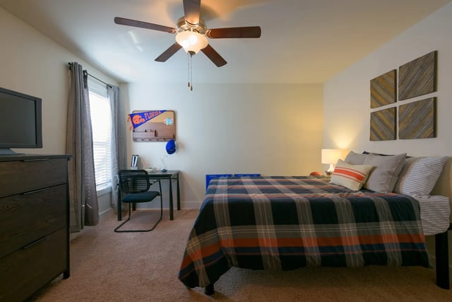 Plaid bed dresser desk chair Florida pennant bedroom at The Retreat at Gainesville in Gainesville Student Accommodation