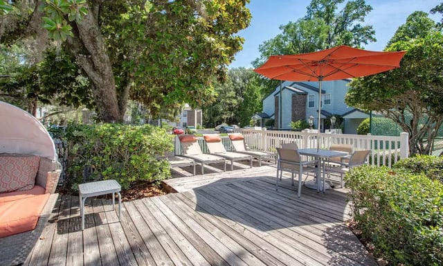 Deck lounge chairs table umbrella outdoor area at Spyglass Apartments in Gainesville Student Accommodation