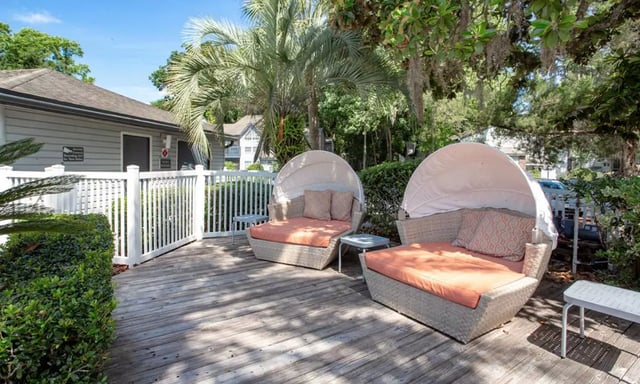 Two cabana loungers with cushions and side tables exterior at Spyglass Apartments in Gainesville Student Accommodation