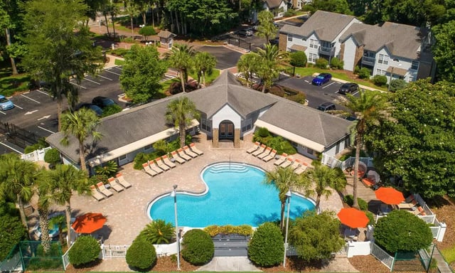 Swimming pool with lounge chairs exterior. at Spyglass Apartments in Gainesville Student Accommodation