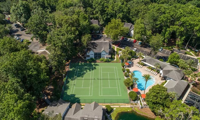 Tennis courts pool and buildings exterior at Spyglass Apartments in Gainesville Student Accommodation