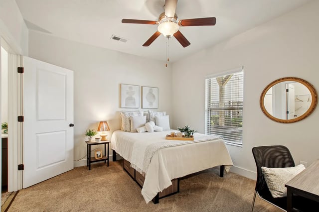 Bed side table lamp art mirror ceiling fan bedroom at The Station Alafaya in Orlando Student Accommodation