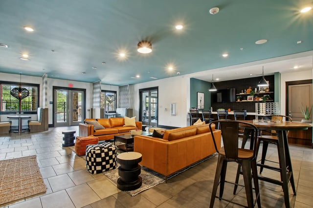 Leather couches coffee tables bar area living room at The Station Alafaya in Orlando Student Accommodation